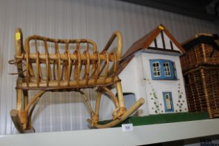 A painted wooden dolls house mounted on board and