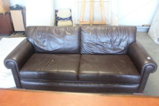 A brown leather upholstered three seater settee