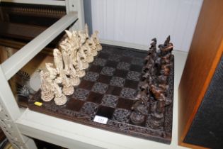 A carved chess board and fantasy chess pieces