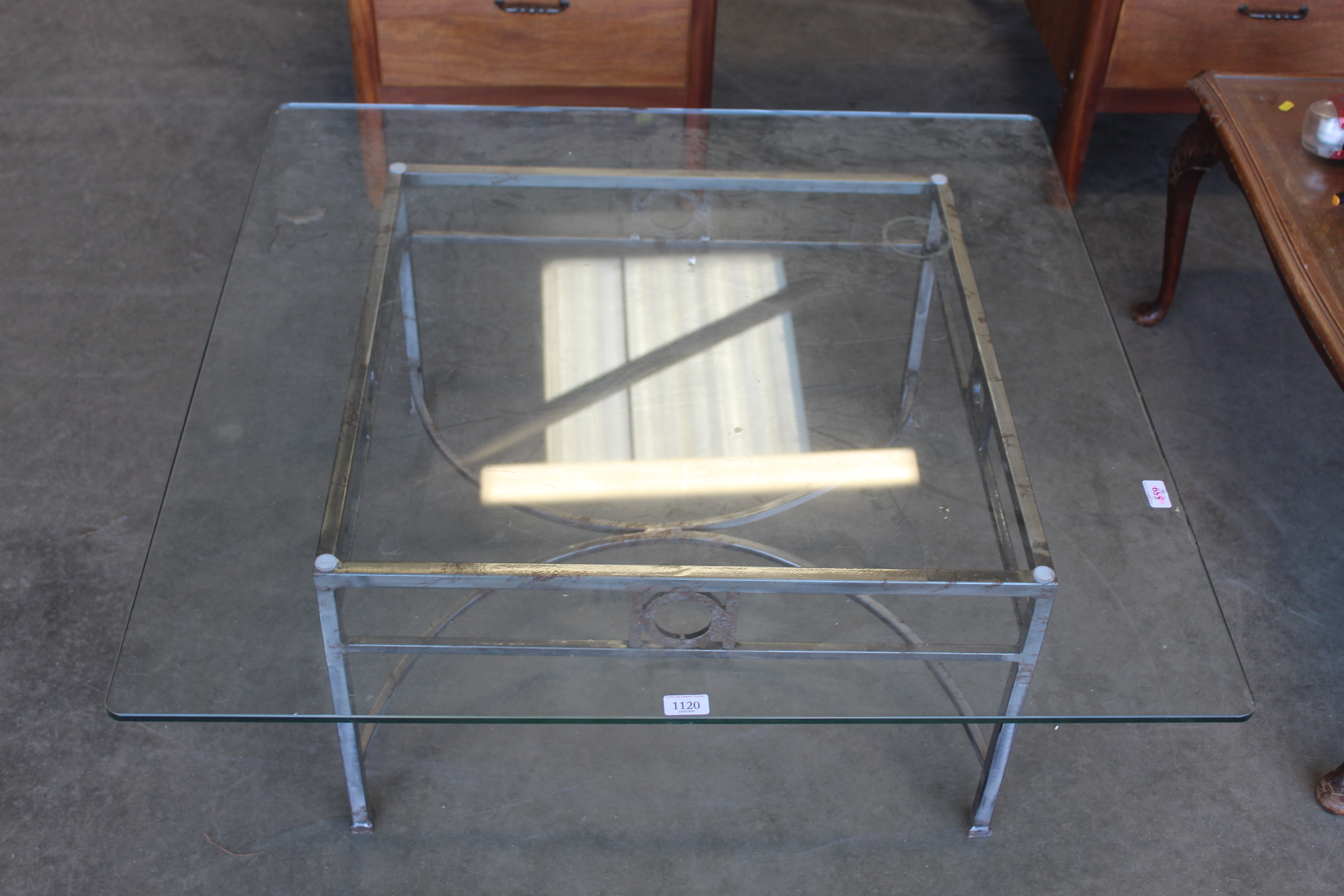 A glass topped coffee table with metal base