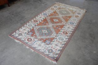 An approx. 9" x 4'10" Persian patterned rug AF