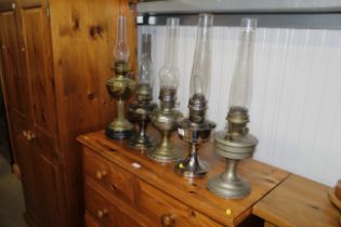 Four various metal oil lamps with glass chimneys a