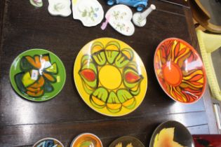 A Poole 'Delphis' patterned pottery bowl on red/orange ground, a Poole 'Delphis' charger on yellow