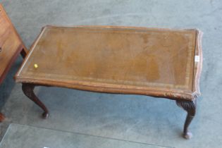 A leather inset coffee table with glass top raised