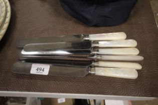 Six mother of pearl handled table knives with silv