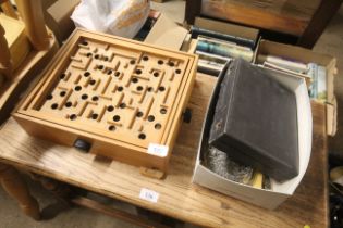 A wooden puzzle game and a box of various silver p