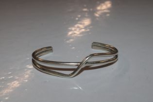 A sterling silver cross over torque bangle, approx. 21gms