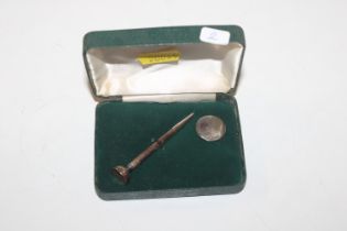 A silver golfing Tee pen and ball marker