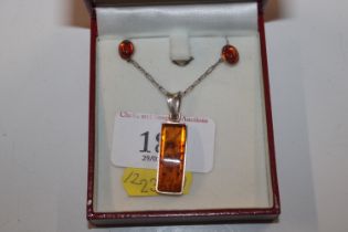 A sterling silver and amber pendant necklace and e