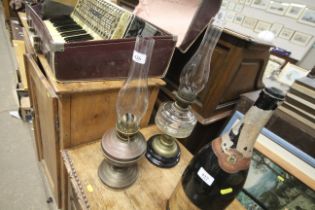 A brass oil lamp with glass chimney and another gl