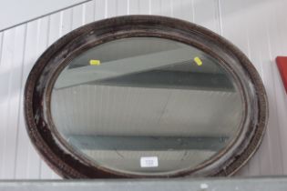 An oval framed and bevel edged wall mirror