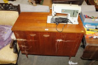 A Singer sewing machine in cabinet