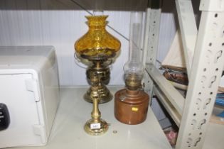 A copper oil lamp and two brass lamps