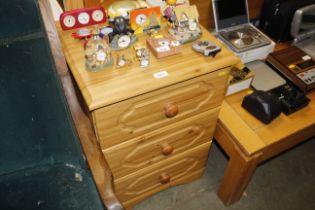 A pine effect bedside chest fitted three drawers