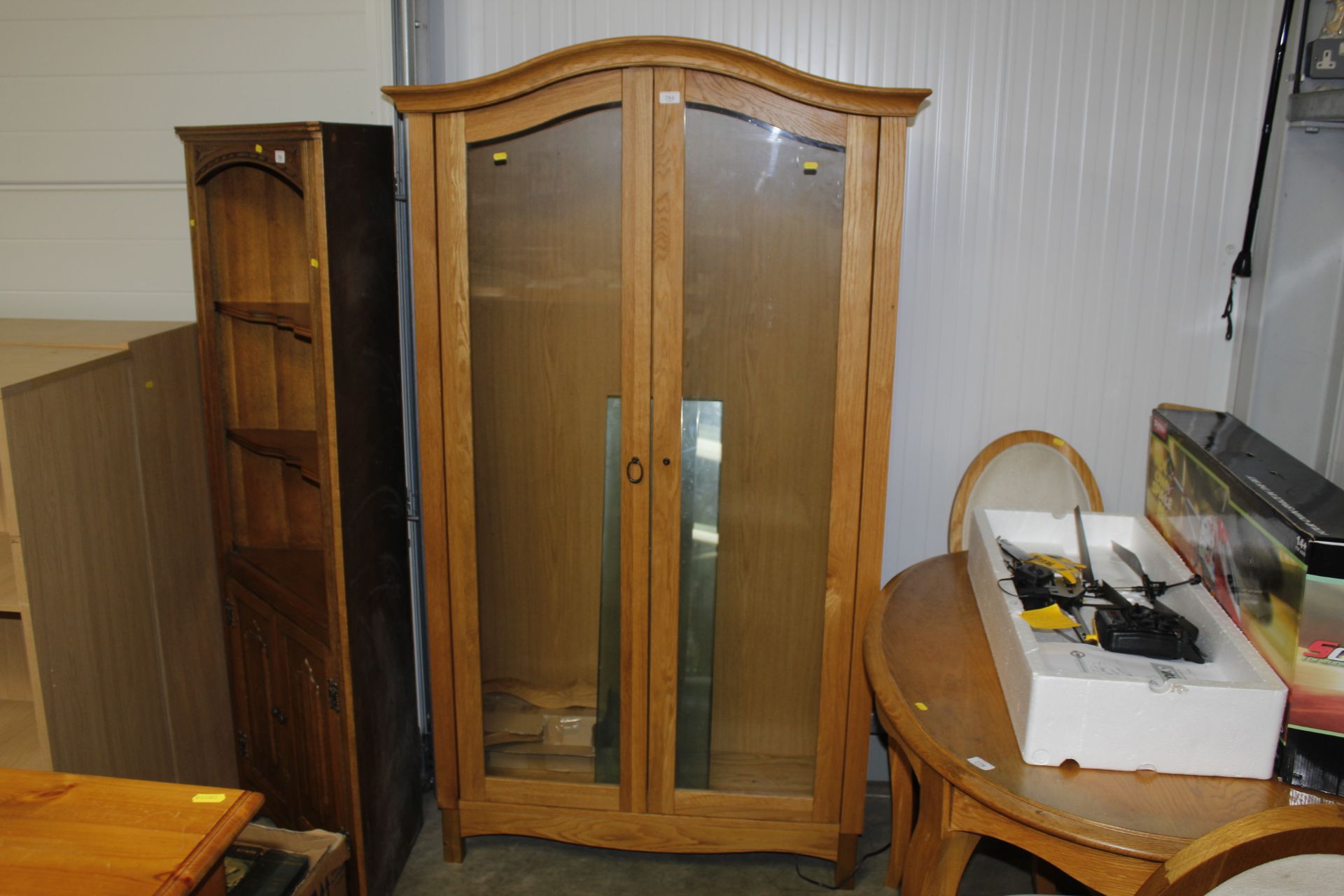 A modern light oak and glazed display cabinet