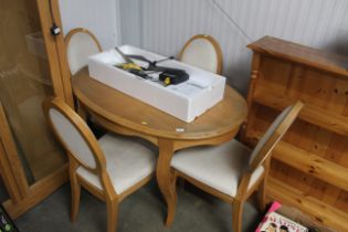 A light oak dining table and four upholstered chai