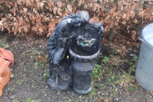 A black painted plastic water feature in the form