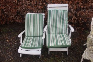 Two white plastic garden lounger chairs with cushi