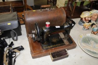 A Singer hand sewing machine in fitted case