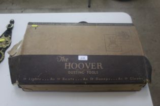 A box containing vintage hoover accessories