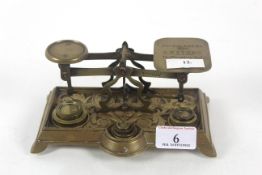 An ornate set of brass postal scales with part set of brass weights 'Not to Exceed 4oz'