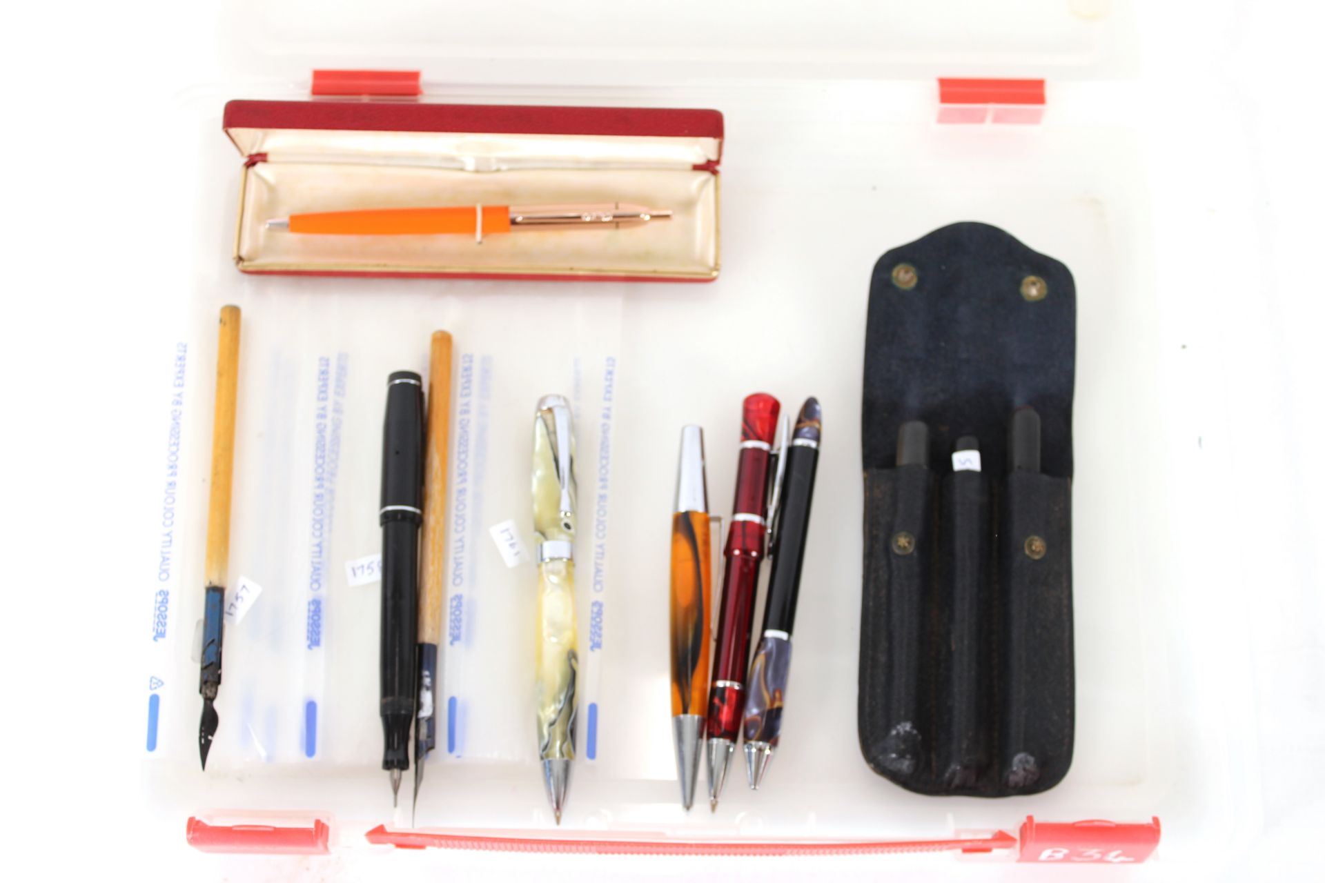 A box containing various ball point pens etc.