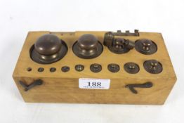 A wooden mounted set of brass metric weights (one missing) extra weights and case AF