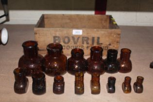 Fourteen various size Bovril jars and a wooden Bov
