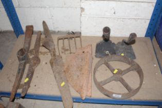 Two pick axe heads, a metal wheel, plough points e