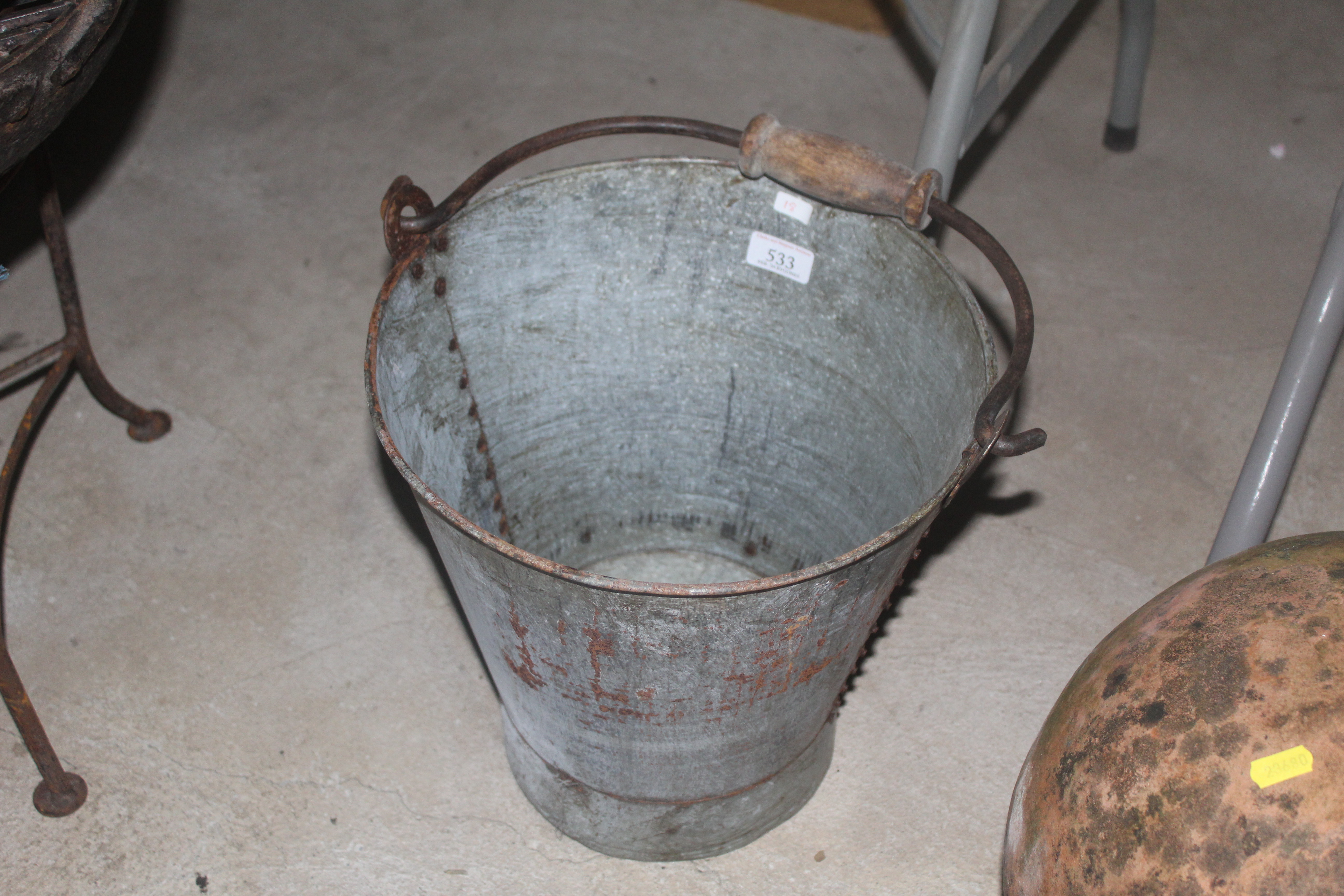 A cast iron pail with swing wooden and metal handl