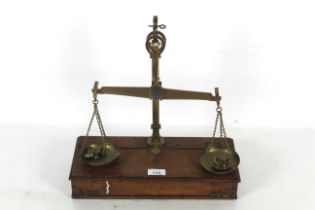 A travelling brass set of balance scales with box base to weigh 1lb with various weights