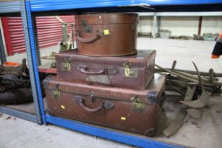 Two vintage leather suitcases and a leather hat bo