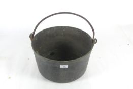 A large brass cooking pot with metal swing handle