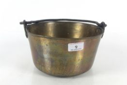 A brass jam pan with iron swing handle