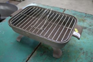 A small cast iron table top BBQ unit on stand