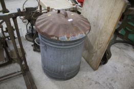 A galvanised metal dustbin