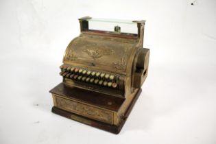 A brass and wooden National cash register with key