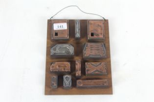 Eleven copper printing blocks: Terrys, spanners, clamps etc. mounted on a board