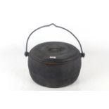 A oval cast iron 4 gallon cooking pot with swing handle and lid by Clarke & Co.