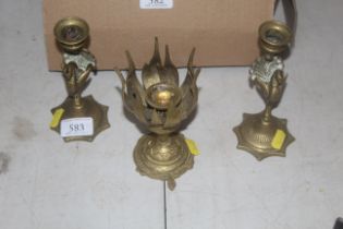 A pair of peacock decorated brass candlesticks and