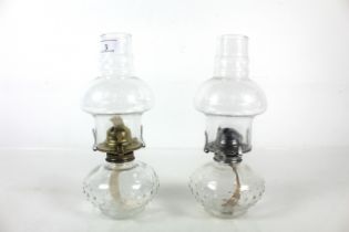 Two glass oil lamps with dimpled glass reservoirs