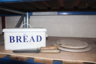 An enamel bread bin, two bread boards and two brea