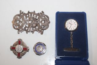 A silver nurses buckle; two nursing badges and a n