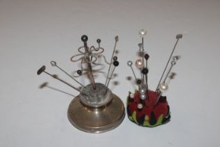 A silver pin cushion; one other pin cushion and va