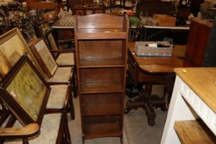 An oak and open fronted book case of narrow propor