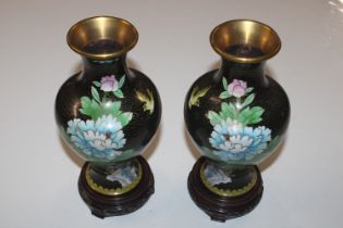 A pair of Cloisonné floral decorated vases on wood