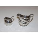 A silver cream jug, marks rubbed and a smaller sil