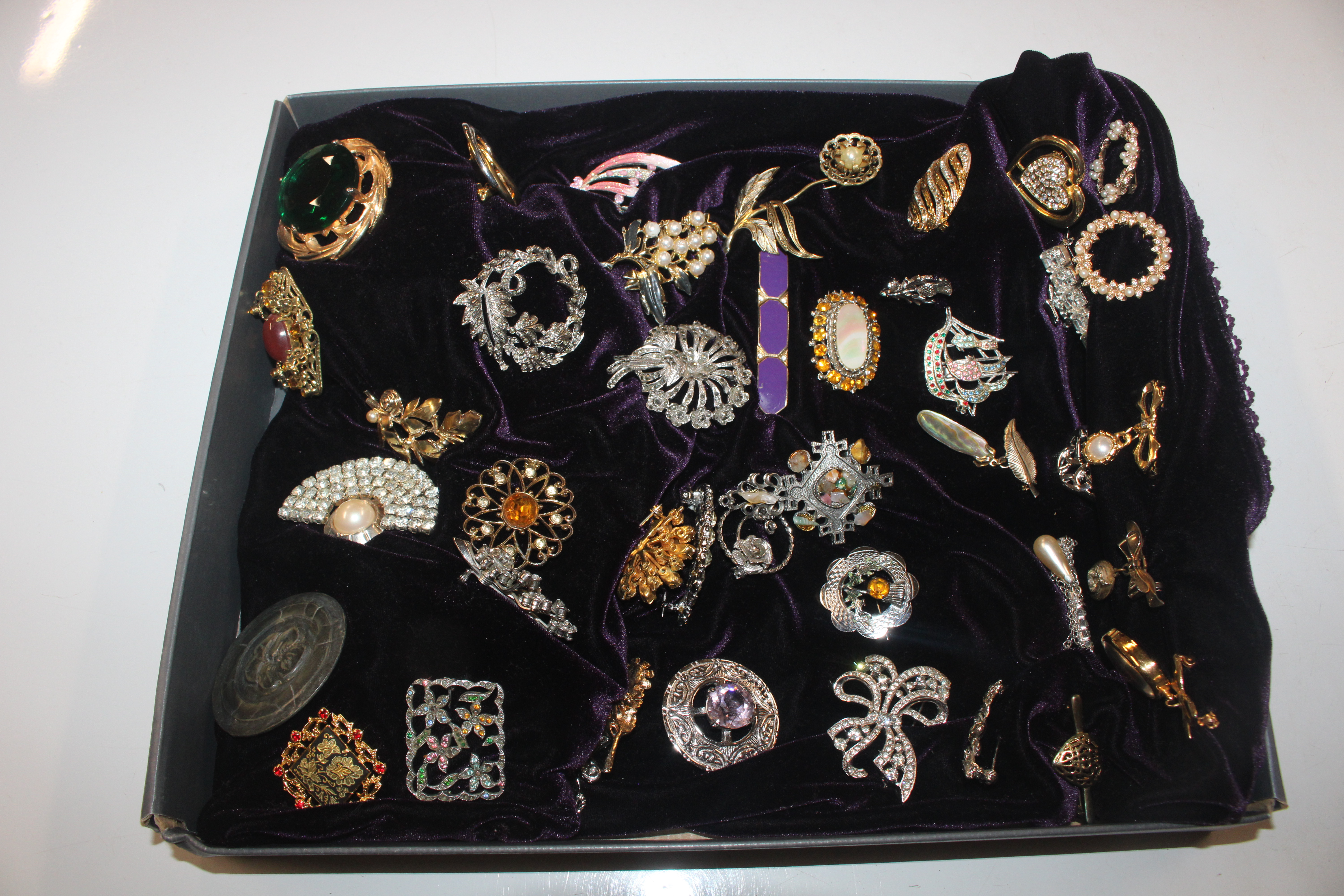 A box of decorative costume brooches