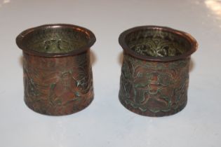 A pair of Eastern copper pots decorated with figur