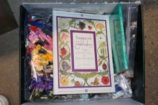 A box of various embroidery items including silks, ribbons, buttons, craft leathers, embroidery book